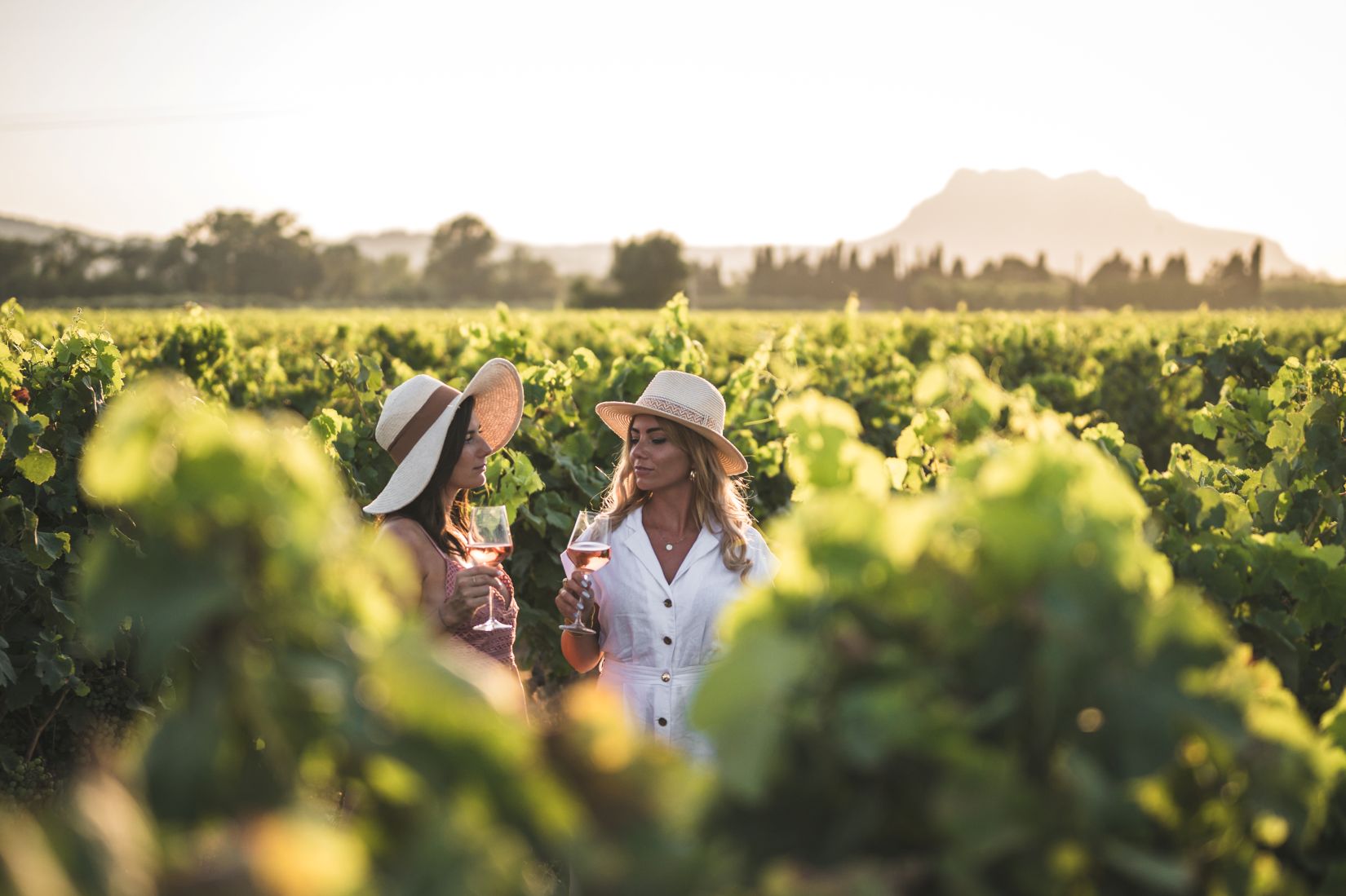 deux filles dans les vignes avec un verre de rosé et le rocher de Roquebrune