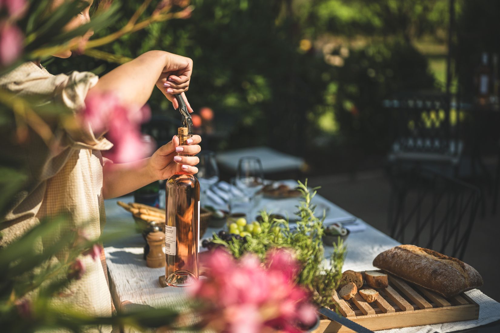 une bouteille de rosé qui est en train d'être débouchonnée