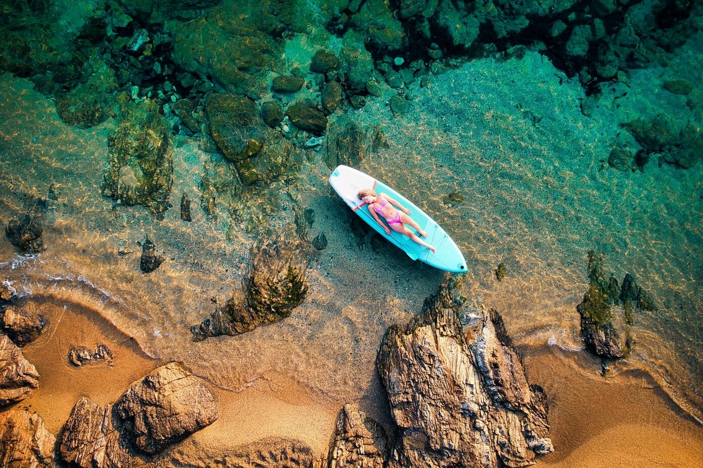 une femme allongée sur le paddle avec une vue aérienne
