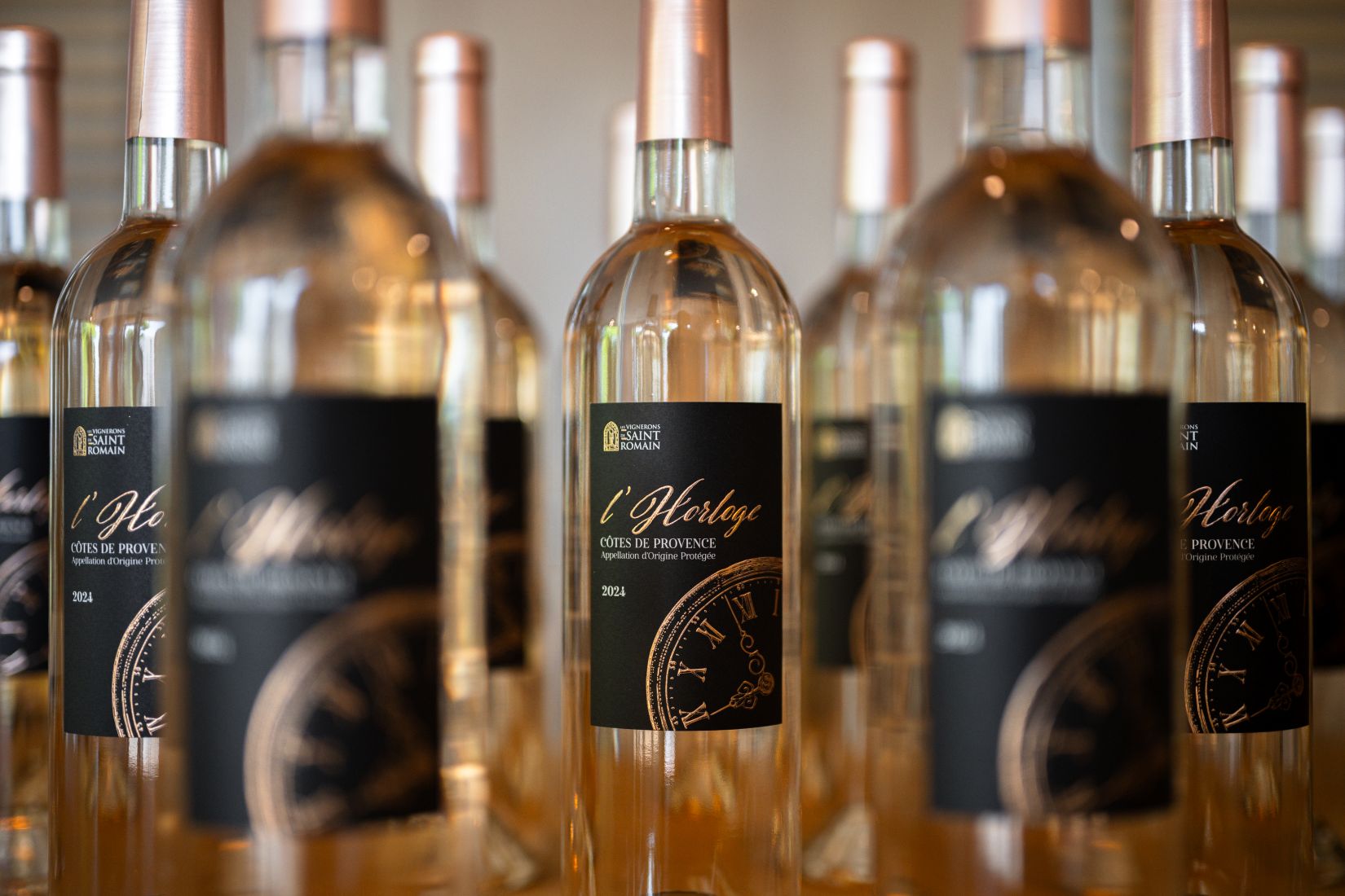 Bouteilles de vin rosé Côtes de Provence « L’Horloge » 2024 alignées, étiquette noire avec motif d’horloge caveua de Saint Romain