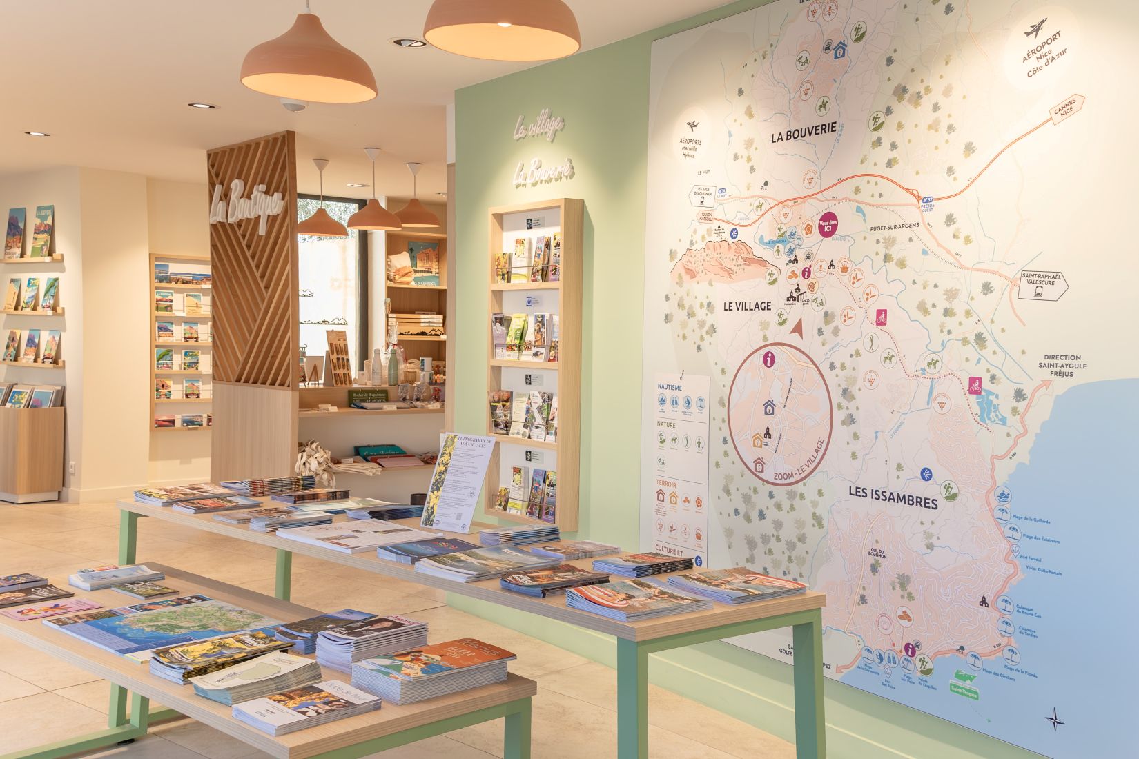 Intérieur de l’office de tourisme avec présentoirs de brochures et grande carte murale de Roquebrune-sur-Argens et des Issambres