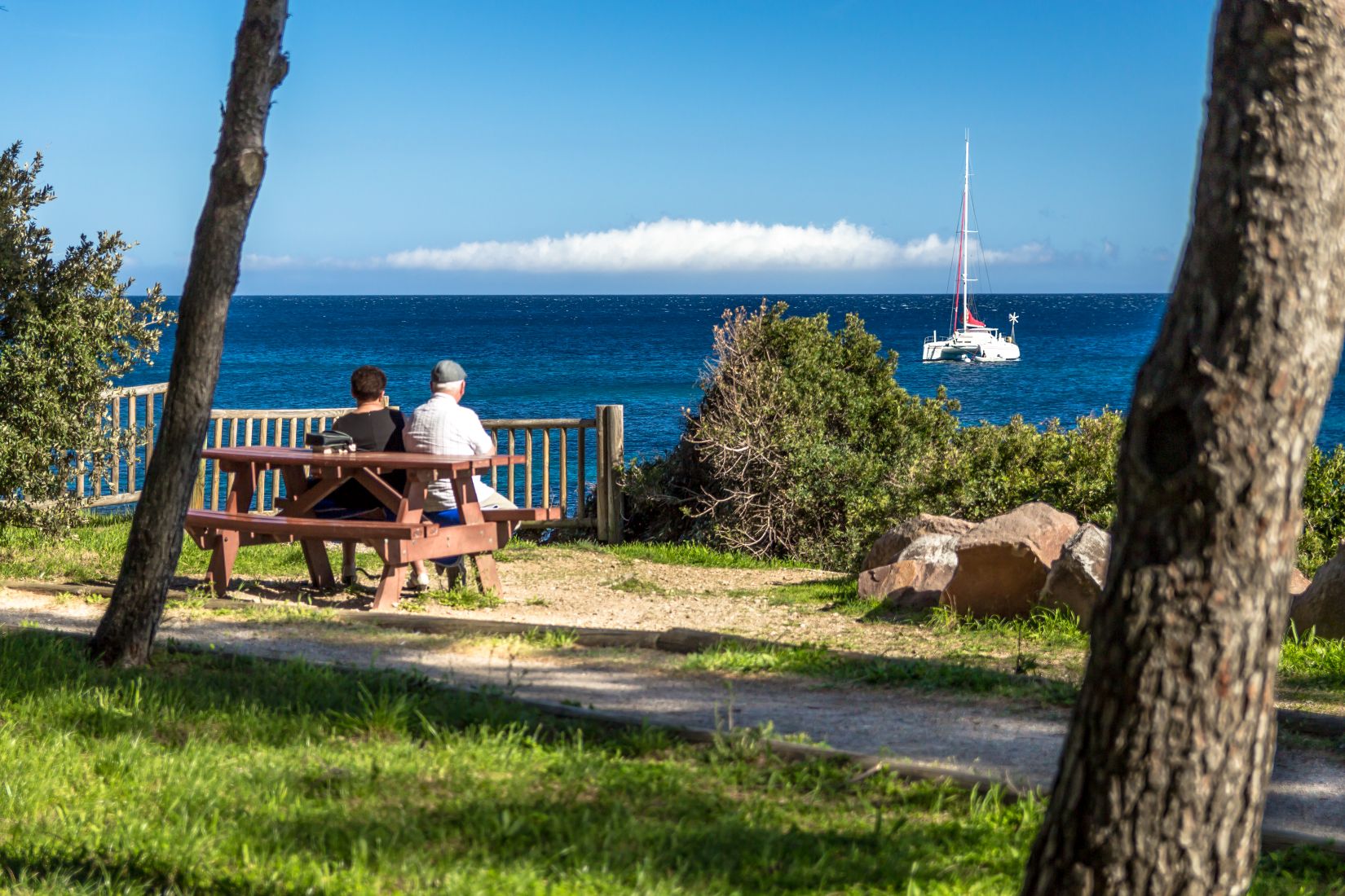 Parc Bédouce aux Issambres avec banc face à la mer et voilier au large sur la Méditerranée