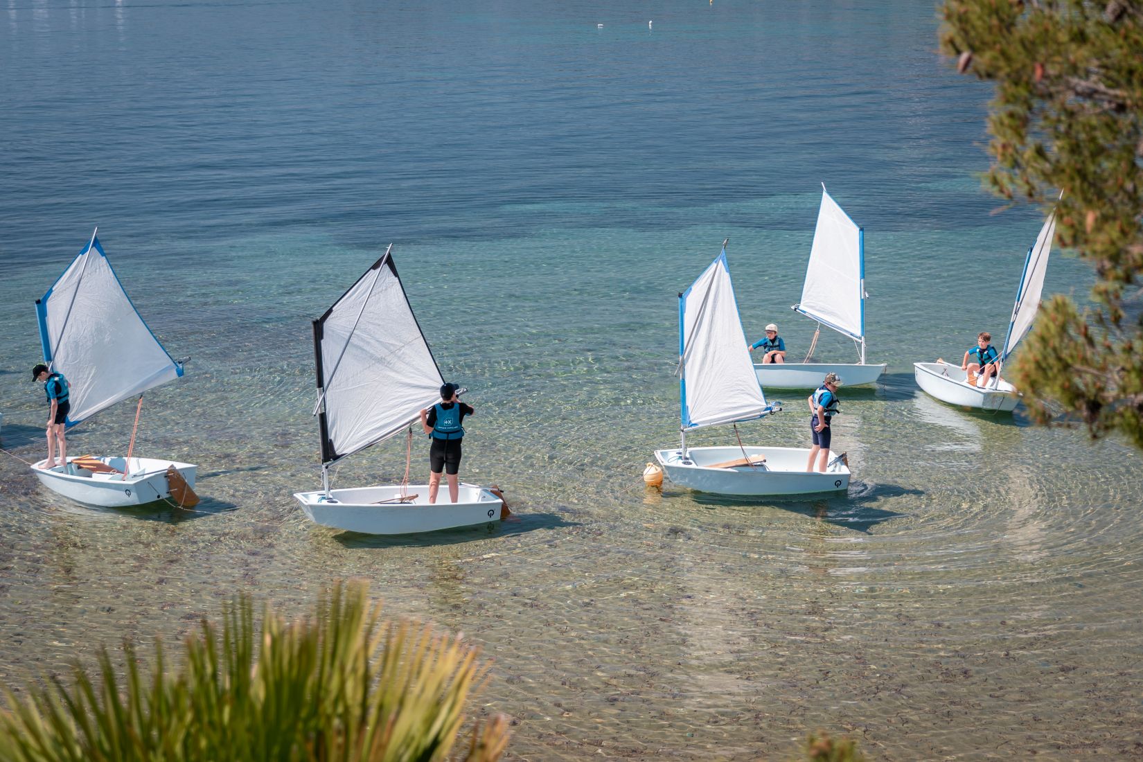Enfants apprenant la voile en optimist dans l’eau turquoise aux Issambres sur la Côte d’Azur