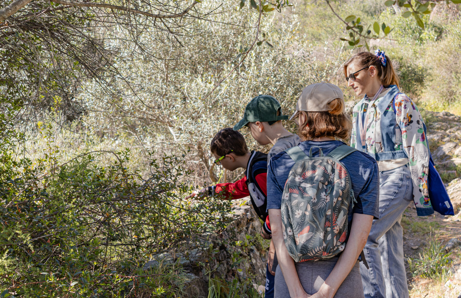 Enfants en atelier nature explorant la végétation avec une animatrice à Roquebrune-sur-Argens
