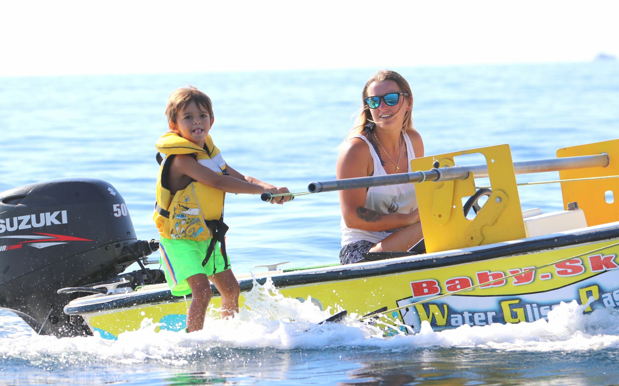 Enfant découvrant le baby ski nautique en mer aux Issambres sous la supervision d'un moniteur.