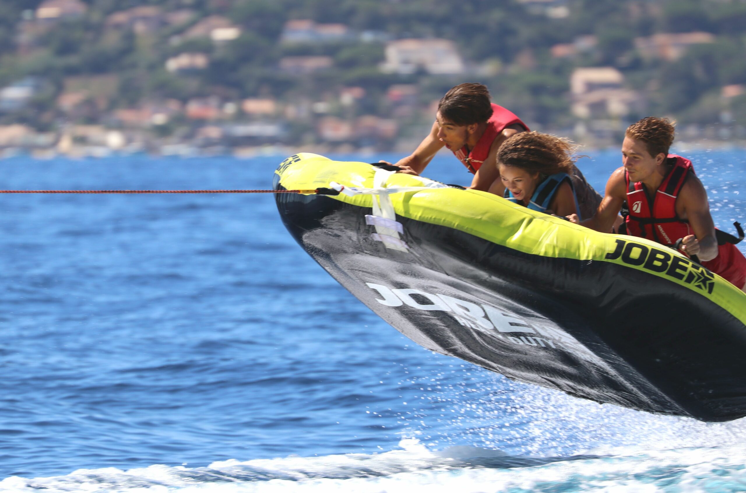 Groupe de vacanciers en bouée tractée sur la Méditerranée aux Issambres, activité nautique à sensations fortes.