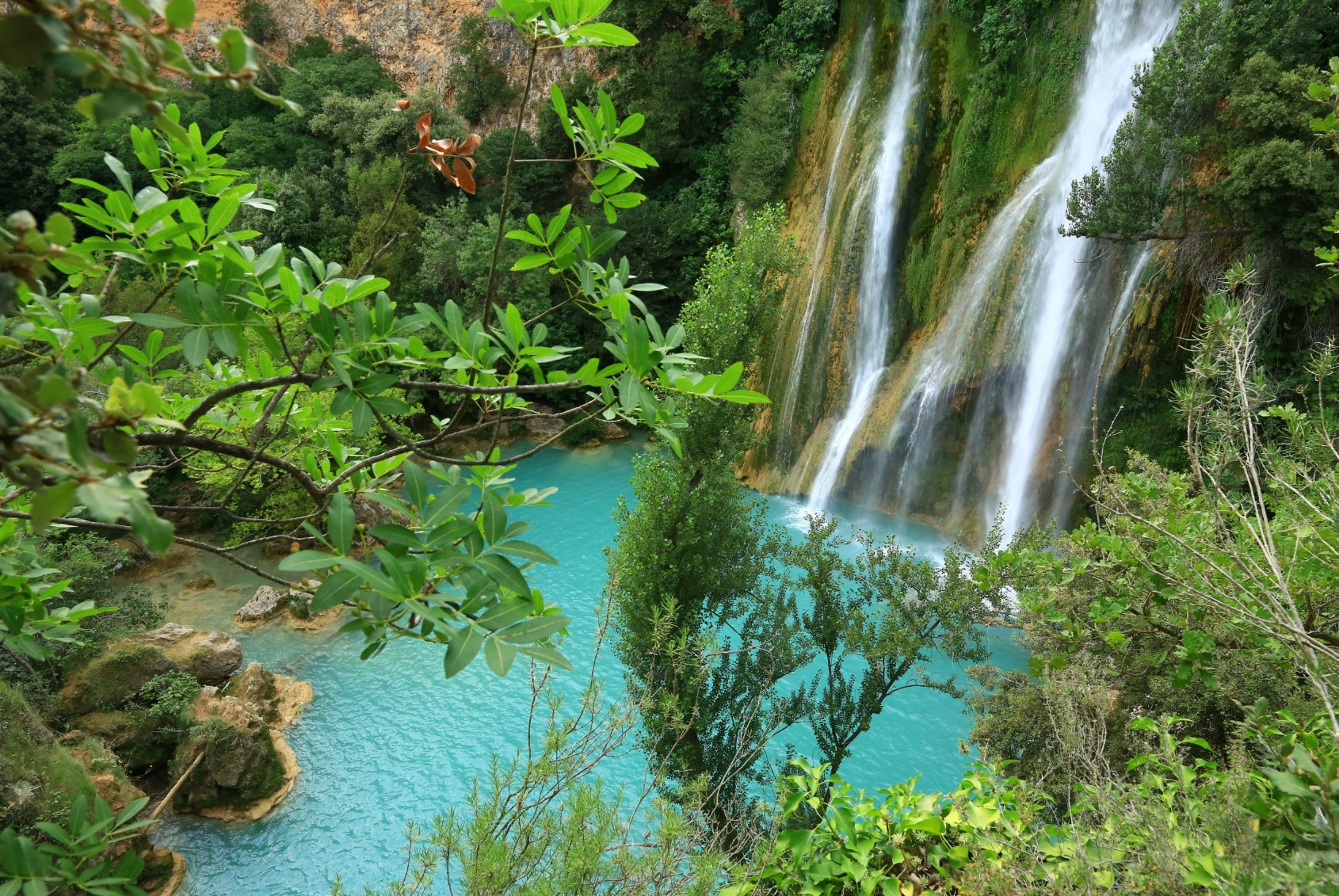 Cascade de Seillans avec bassin d'eau turquoise au cœur d'une végétation luxuriante.