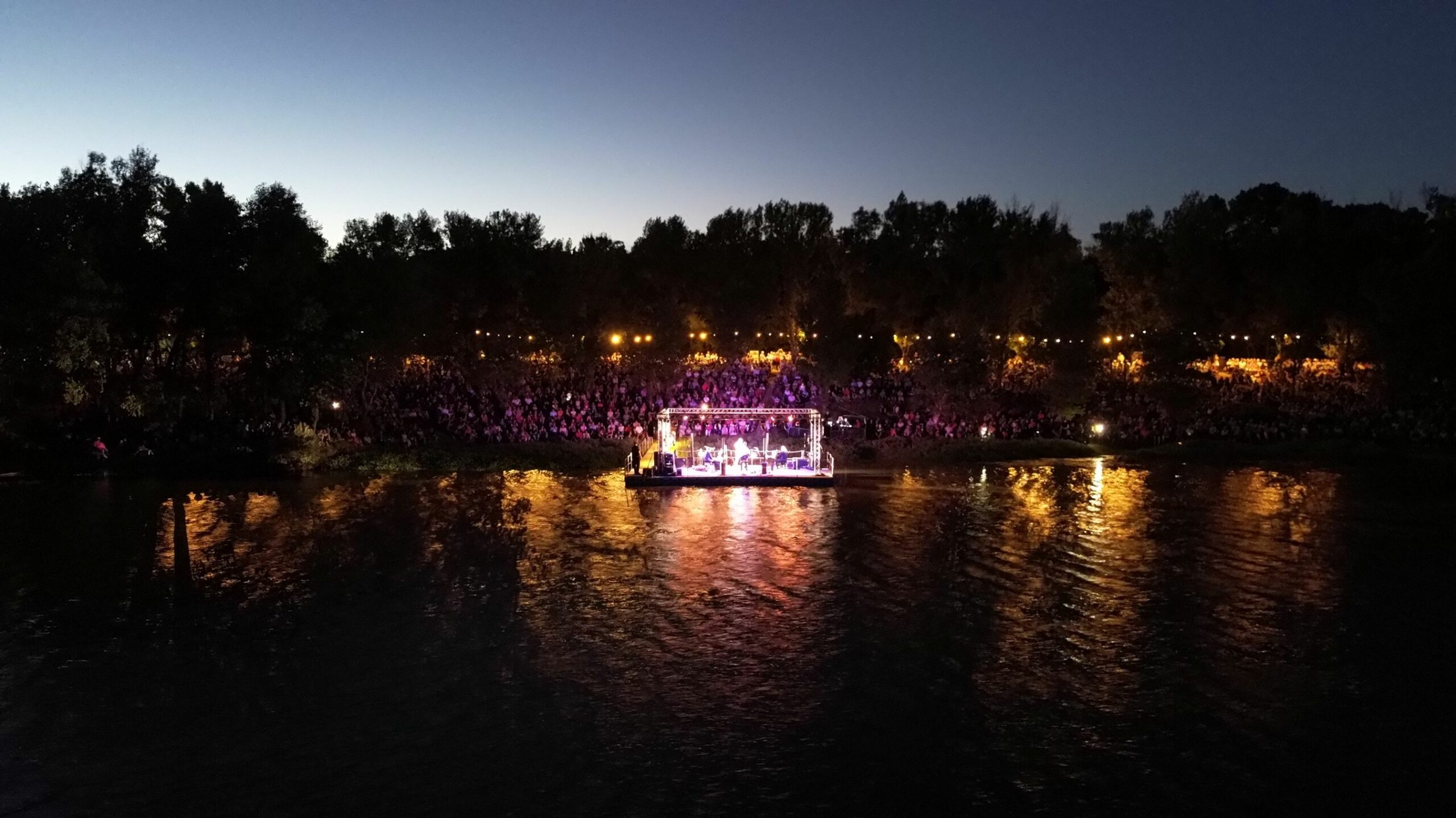 Vue nocturne du festival de concerts au lac de Roquebrune-sur-Argens, public nombreux