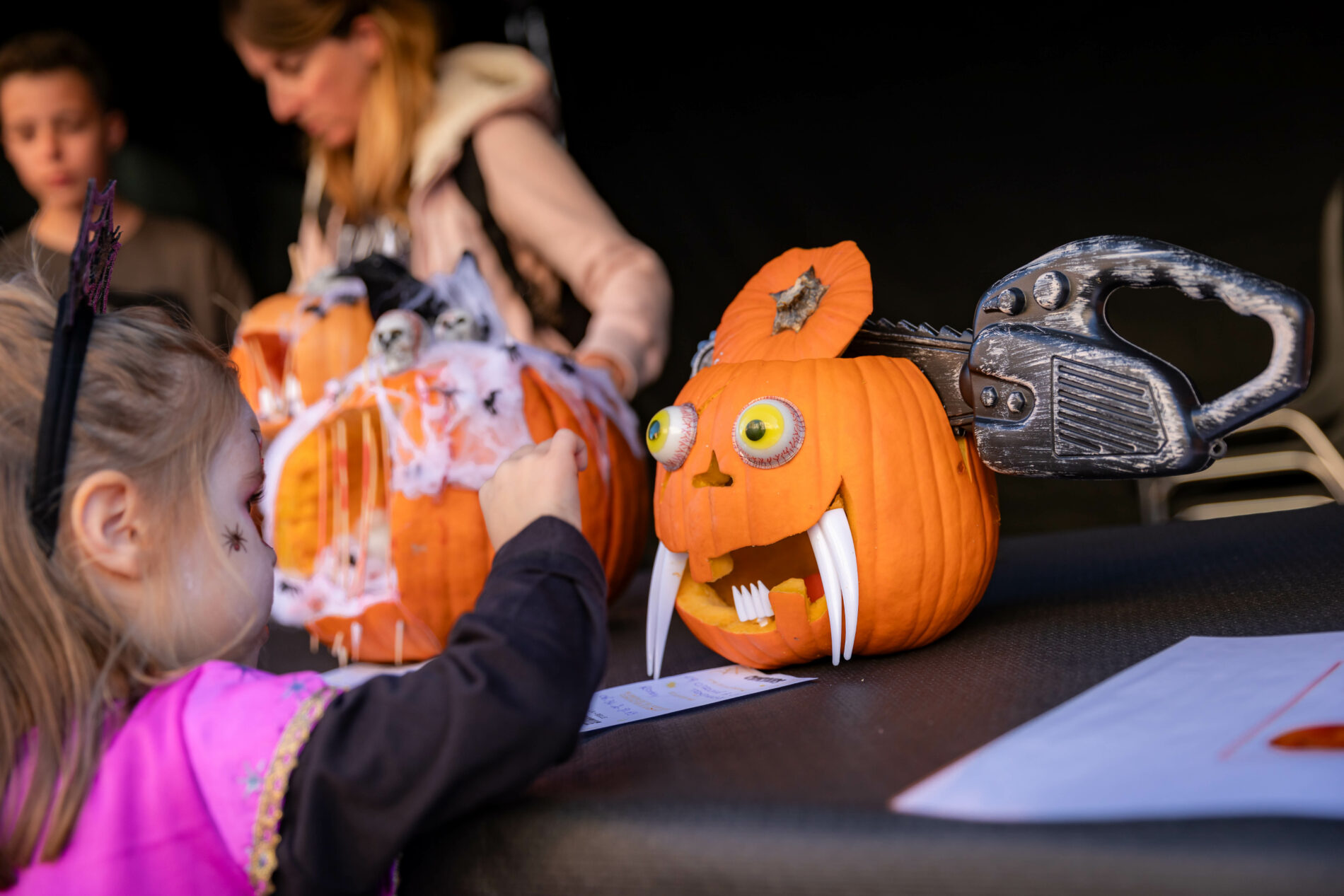 Petite fille déguisée découvrant des citrouilles sculptées et décorées lors des animations d'Halloween à Roquebrune-sur-Argens.